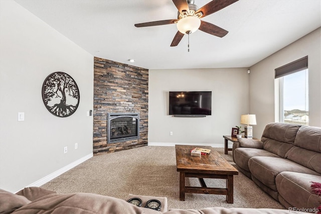 living area featuring ceiling fan, a fireplace, carpet flooring, and baseboards