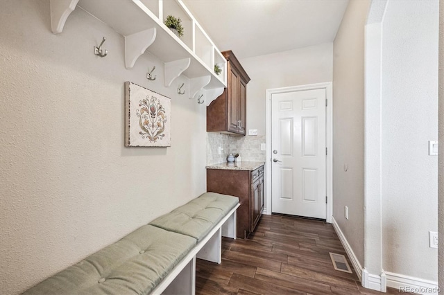 mudroom featuring dark wood-style flooring, visible vents, and baseboards