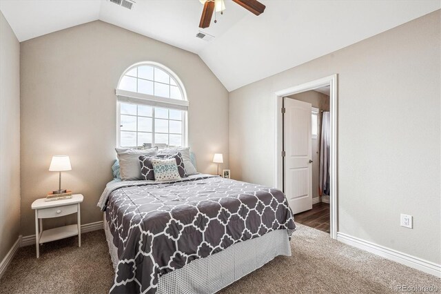 bedroom with lofted ceiling, visible vents, and dark carpet