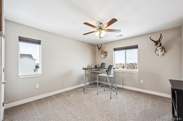 carpeted office featuring baseboards, visible vents, and ceiling fan