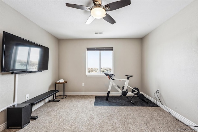 workout area featuring carpet floors, a ceiling fan, visible vents, and baseboards