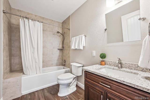 full bathroom featuring shower / tub combo, a textured wall, toilet, wood finished floors, and vanity