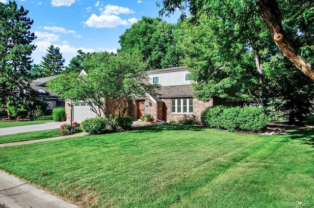 view of property hidden behind natural elements featuring a front yard, concrete driveway, brick siding, and an attached garage