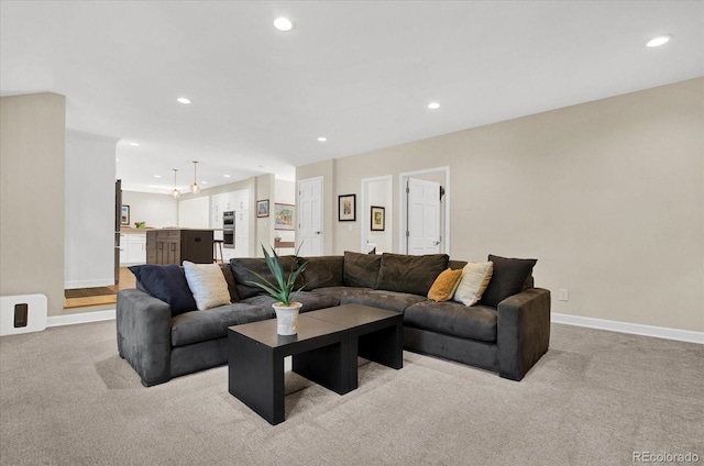 living room with recessed lighting, light colored carpet, and baseboards