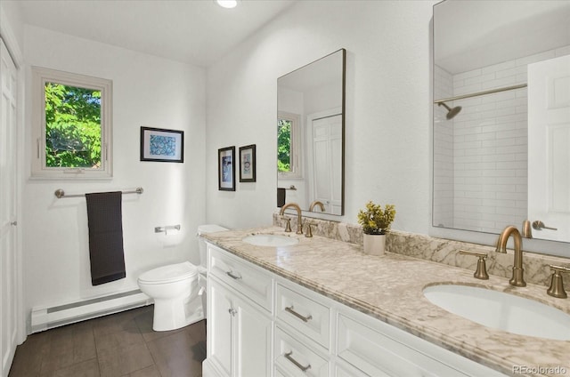 full bathroom featuring a healthy amount of sunlight, a baseboard radiator, and a sink