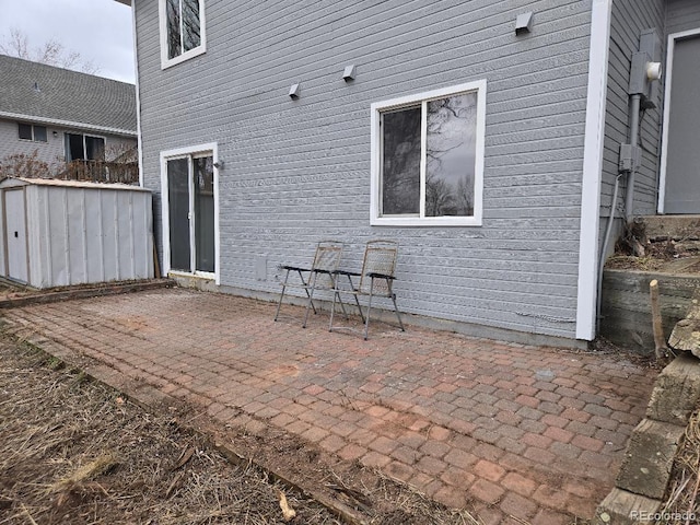 view of patio / terrace featuring a storage unit and an outdoor structure