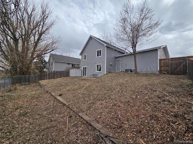 rear view of house featuring a storage shed, cooling unit, a fenced backyard, and an outdoor structure