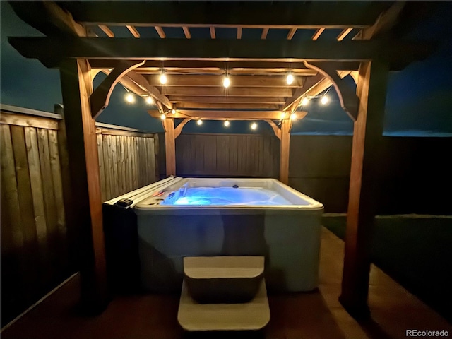 view of patio / terrace featuring fence and a hot tub