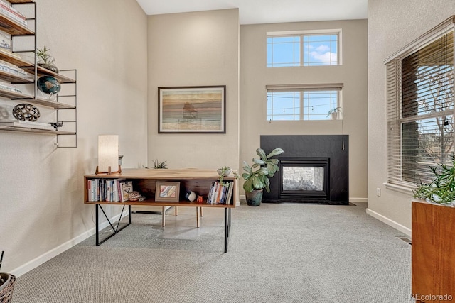 foyer entrance featuring a towering ceiling and carpet floors