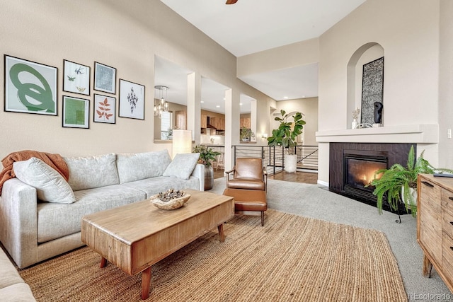 carpeted living room with an inviting chandelier