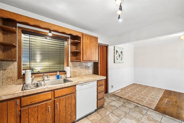 kitchen with white dishwasher, decorative backsplash, sink, and tile counters