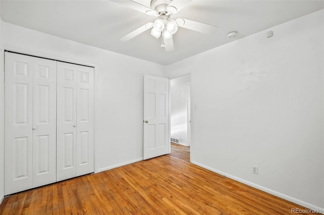 unfurnished bedroom with ceiling fan, a closet, and light wood-type flooring