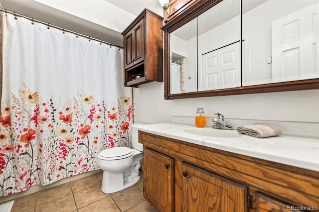 bathroom with tile patterned flooring, vanity, and toilet