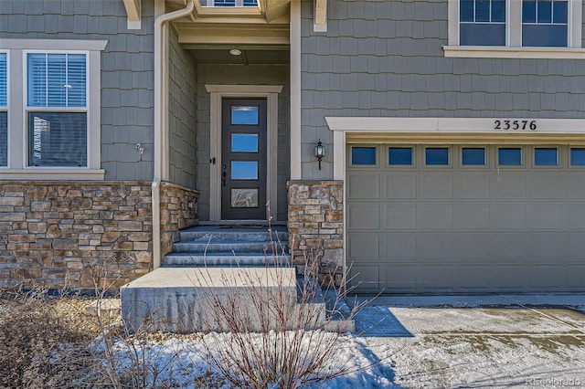 entrance to property featuring a garage and stone siding