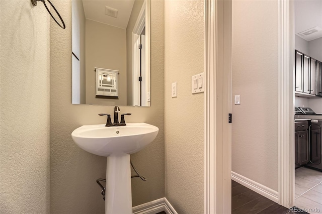 bathroom with baseboards, visible vents, wood finished floors, and independent washer and dryer