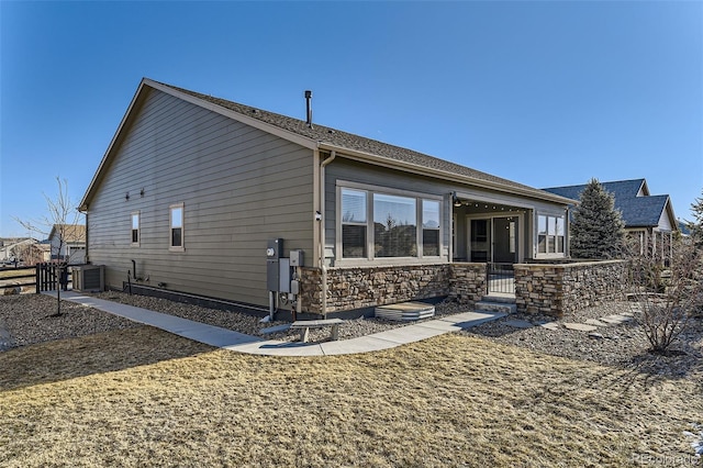 exterior space with stone siding, fence, and central AC unit