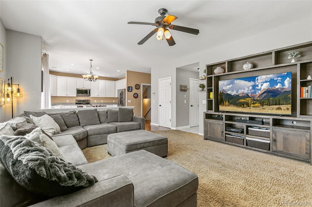 living area with ceiling fan with notable chandelier, light colored carpet, baseboards, and recessed lighting
