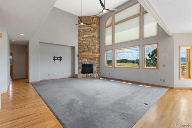 1680 Elk View Rd, Larkspur, CO 80118 - unfurnished living room featuring ceiling fan, a fireplace, wood finished floors, and high vaulted ceiling