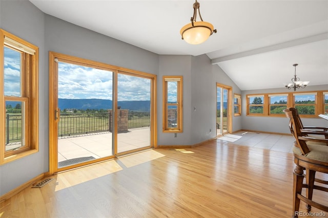 1680 Elk View Rd, Larkspur, CO 80118 - unfurnished dining area with a chandelier, wood finished floors, and a mountain view
