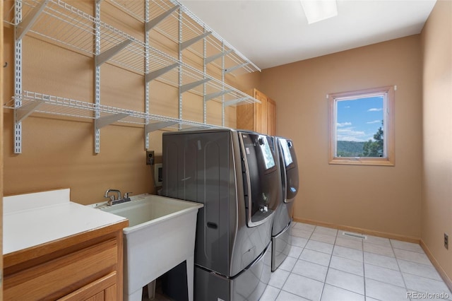 1680 Elk View Rd, Larkspur, CO 80118 - laundry area featuring washing machine and clothes dryer, cabinet space, and light tile patterned floors