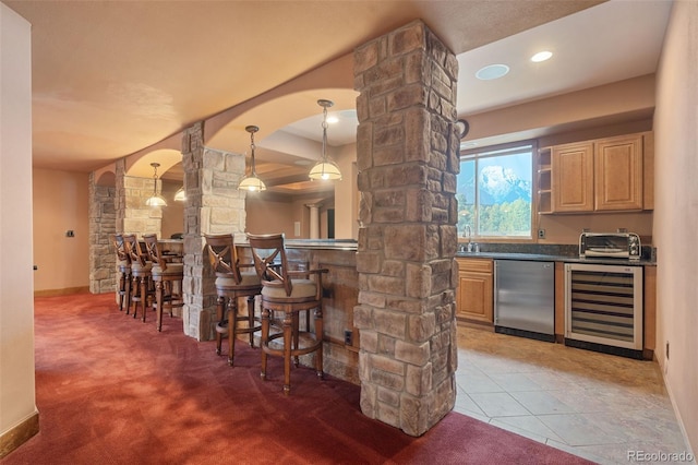 1680 Elk View Rd, Larkspur, CO 80118 - indoor wet bar featuring beverage cooler, ornate columns, stainless steel dishwasher, and carpet floors