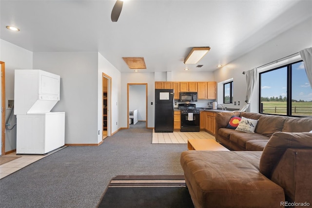 1680 Elk View Rd, Larkspur, CO 80118 - living area featuring stacked washer and clothes dryer, light colored carpet, and a ceiling fan