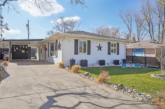 view of front of home featuring a carport, a front lawn, driveway, and stucco siding