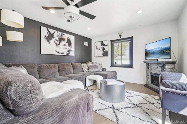 living room featuring a fireplace, a ceiling fan, recessed lighting, wood finished floors, and baseboards