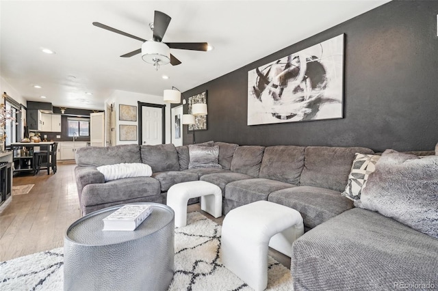 living room featuring recessed lighting, light wood finished floors, and a ceiling fan