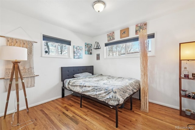 bedroom featuring baseboards and wood finished floors