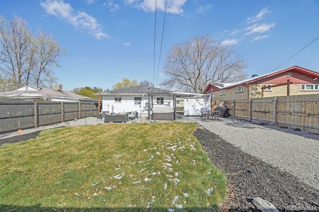 back of house featuring a patio area, a fenced backyard, a lawn, and a hot tub