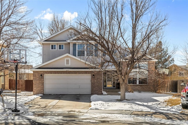 traditional home with a garage, concrete driveway, brick siding, and fence