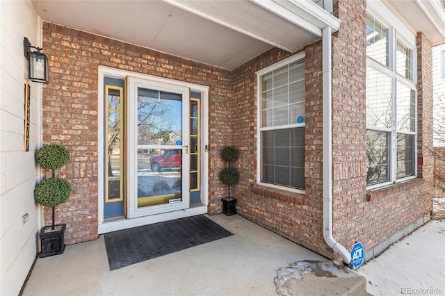 view of exterior entry featuring brick siding