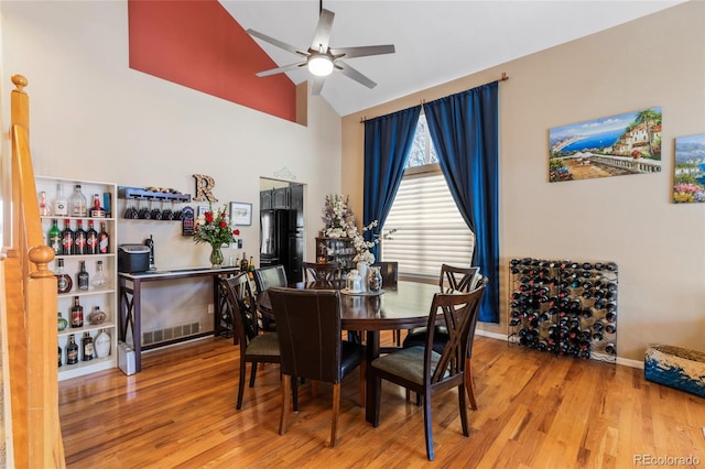 dining area with a ceiling fan, lofted ceiling, baseboards, and wood finished floors