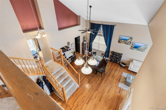 dining room with lofted ceiling, light wood-style flooring, stairs, and ceiling fan