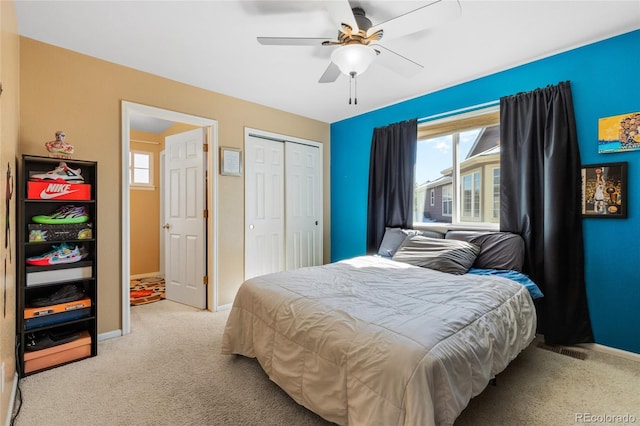 bedroom with light colored carpet, visible vents, baseboards, a ceiling fan, and a closet