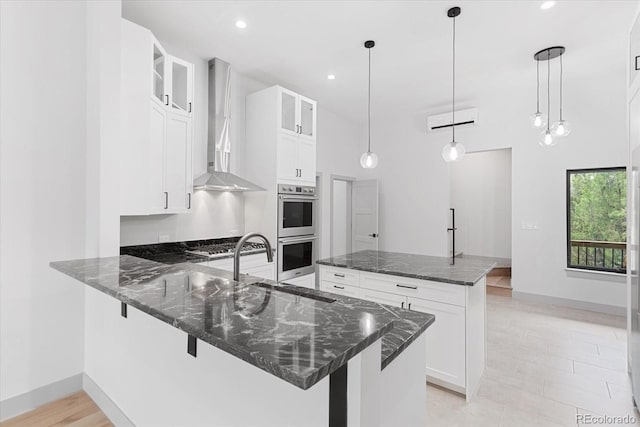 7916 Cozart Ln, Salida, CO 81201 - kitchen featuring wall chimney exhaust hood, double oven, glass insert cabinets, dark stone countertops, and recessed lighting