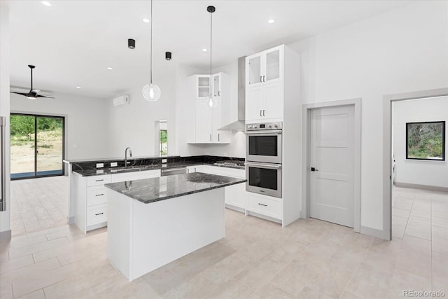 7916 Cozart Ln, Salida, CO 81201 - kitchen with a peninsula, appliances with stainless steel finishes, glass insert cabinets, dark stone countertops, and white cabinetry