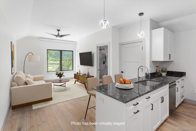 7916 Cozart Ln, Salida, CO 81201 - kitchen featuring open floor plan, stainless steel dishwasher, a breakfast bar area, and white cabinets