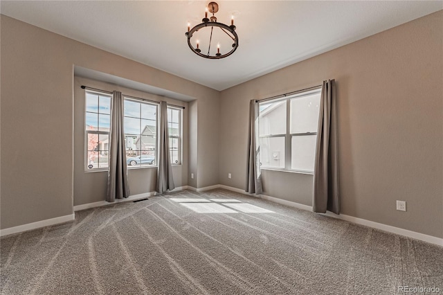 spare room with an inviting chandelier and light colored carpet