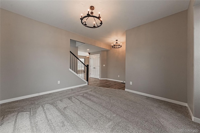 unfurnished living room featuring a chandelier and dark colored carpet