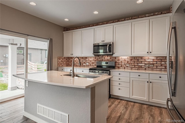 kitchen with white cabinetry, sink, a center island with sink, and appliances with stainless steel finishes