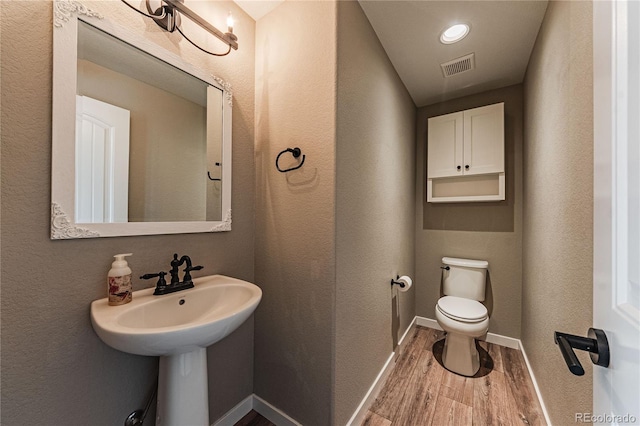 bathroom with toilet and hardwood / wood-style floors