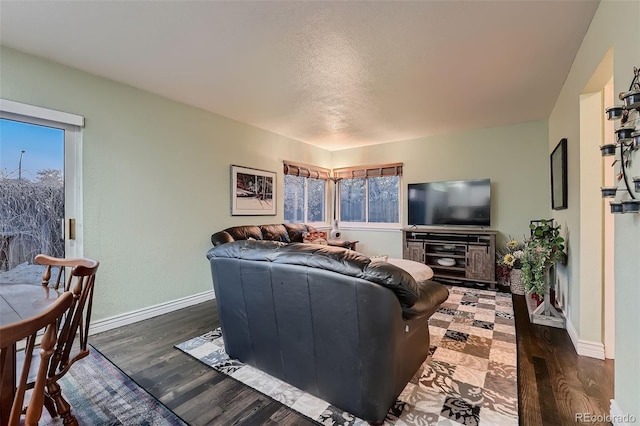 living room with a textured ceiling, plenty of natural light, and dark hardwood / wood-style floors