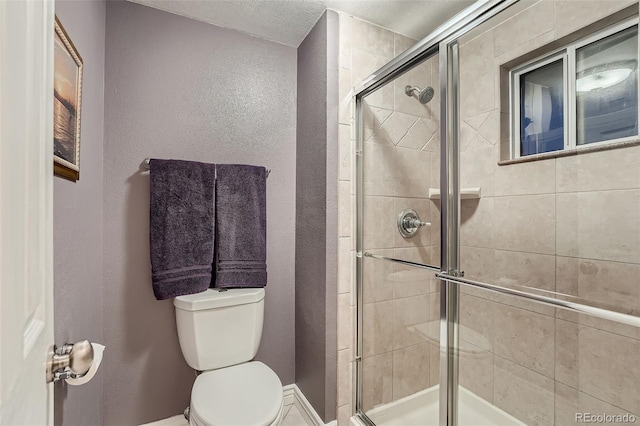 bathroom featuring a textured ceiling, an enclosed shower, and toilet