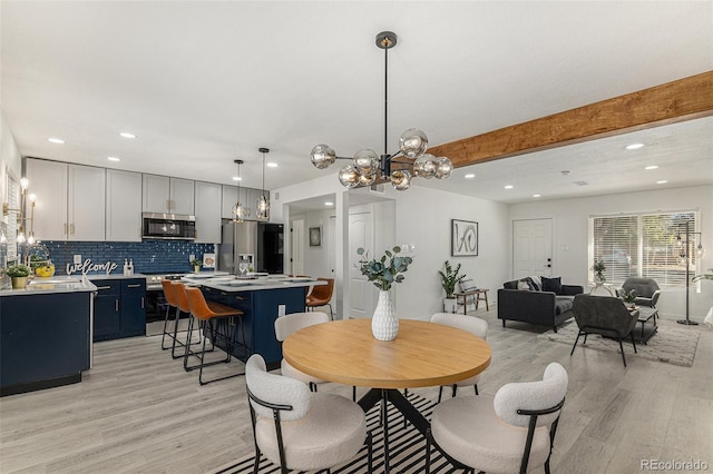 dining room with light hardwood / wood-style flooring, a chandelier, and beam ceiling