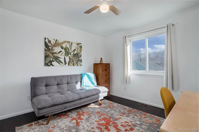 office featuring a ceiling fan, visible vents, baseboards, and wood finished floors