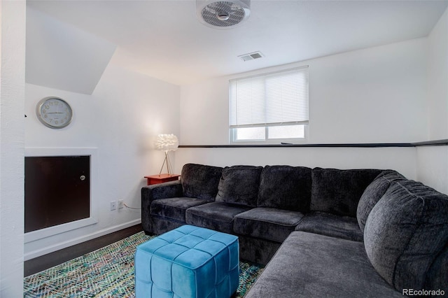 living area featuring visible vents, baseboards, and wood finished floors