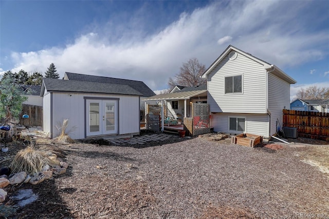 rear view of house with an outbuilding, french doors, fence, and a wooden deck