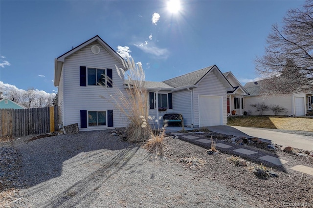 view of front of home with a garage, driveway, and fence